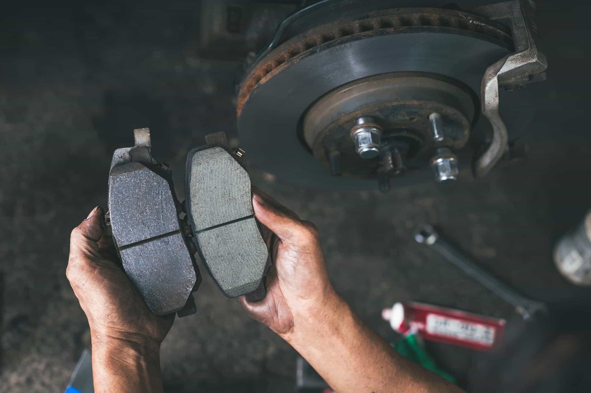 A Mechanic Holds a New, Thick Brake Pad — Berkeley Vale Tyre & Mechanical in Fountaindale, NSW