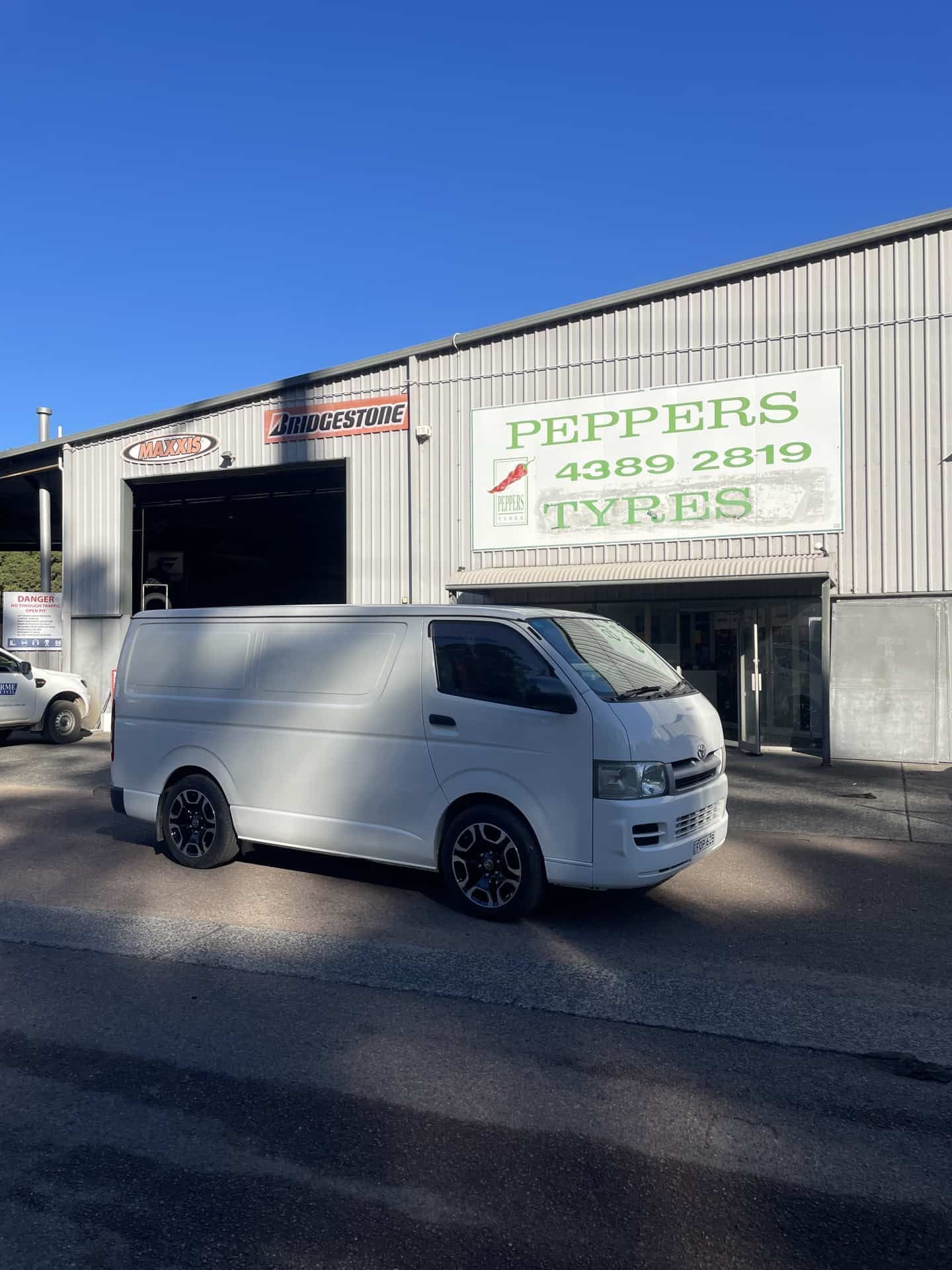A White Van Parked Outside a Commercial Building — Berkeley Vale Tyre & Mechanical in Fountaindale, NSW