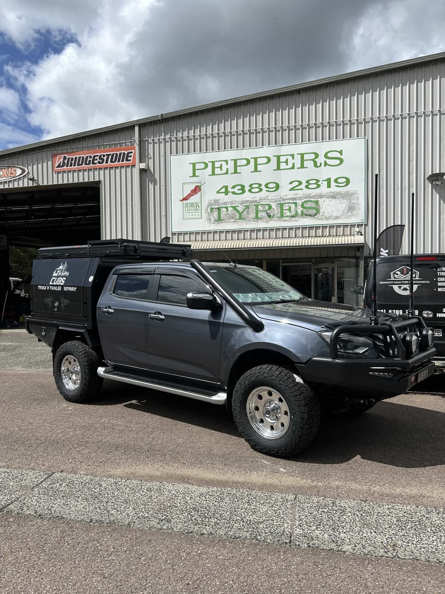 A Gray Pickup Truck With a Black Camper Shell — Berkeley Vale Tyre & Mechanical in Fountaindale, NSW