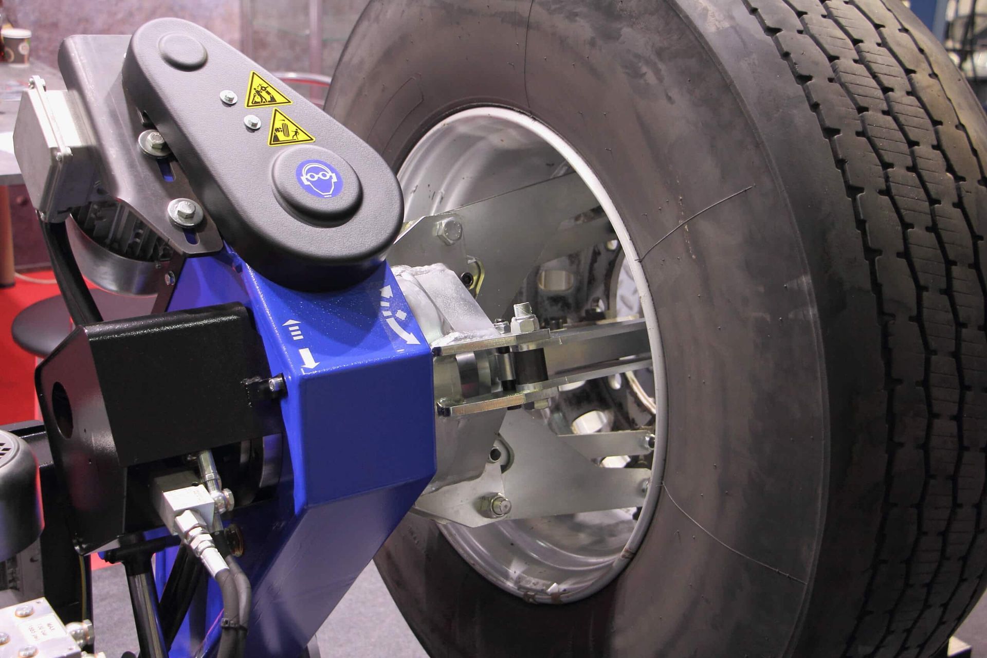 A Blue Industrial Tyre-changing Machine is Mounted Onto the Metal Rim — Berkeley Vale Tyre & Mechanical in Fountaindale, NSW