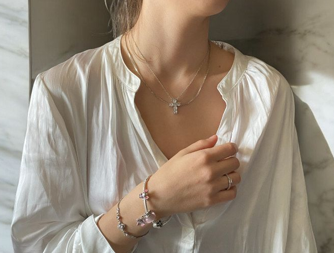 Iemand die een armband om zijn pols draagt, raakt de pols van een ander persoon aan.