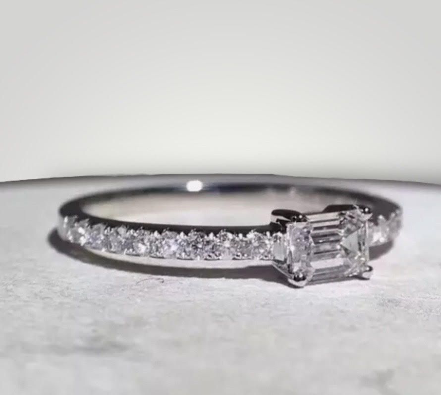 Een close-up van een diamanten ring op een tafel.