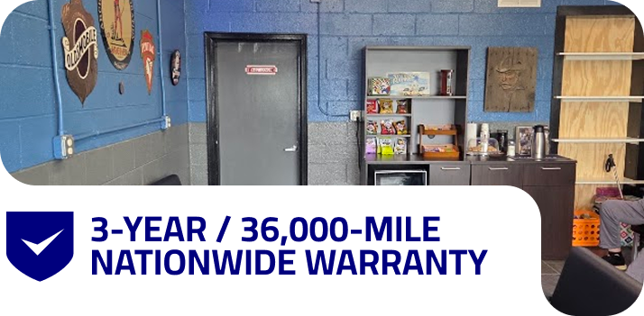 Garage interior with car lift and supplies, plus “3-year/36,000-mile nationwide warranty” banner | West Main Auto Repair