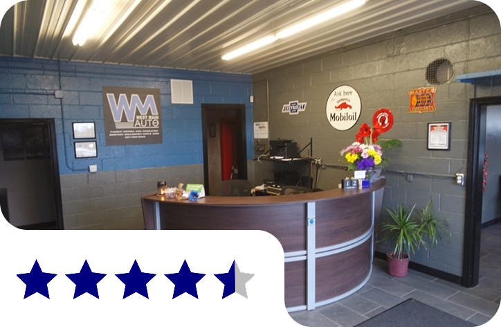 Office reception desk with blue walls, wood counter, flowers, and a 4.5-star rating badge | West Main Auto Repair