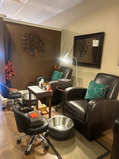Nail salon with two leather chairs, foot basins, and a small table with supplies. Brown and teal accents.
