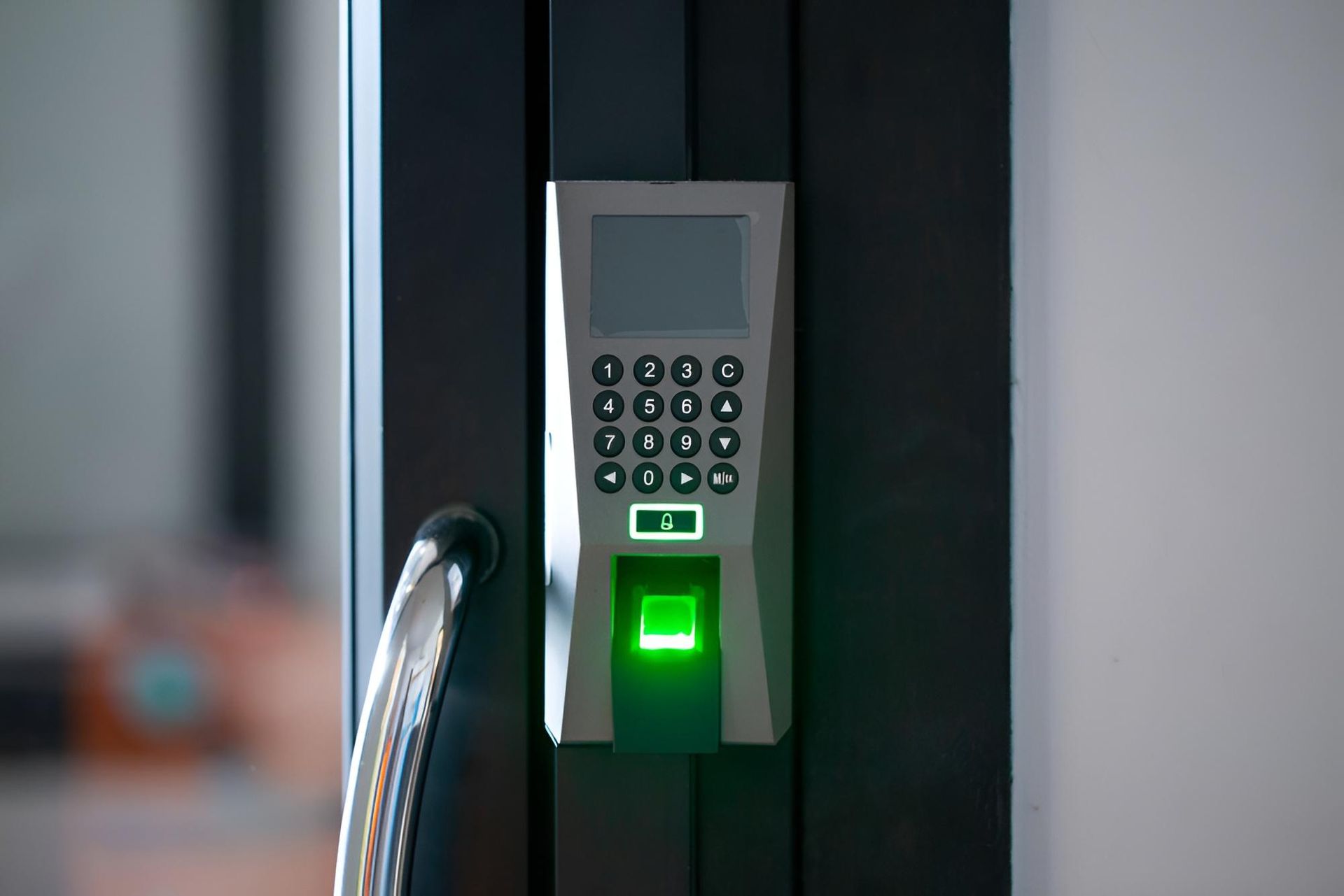 Close-up of keypad access control with green light on a modern door entry security system in office.