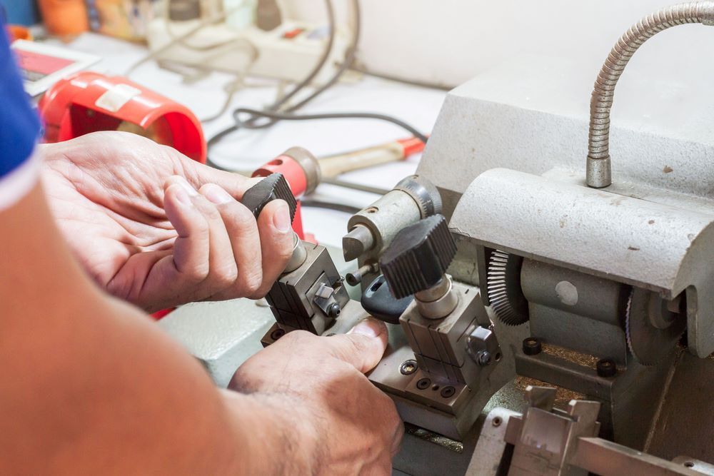 A Person is Cutting a Key With a Machine — Coffs City Lockmart Pty Ltd in Macksville, NSW