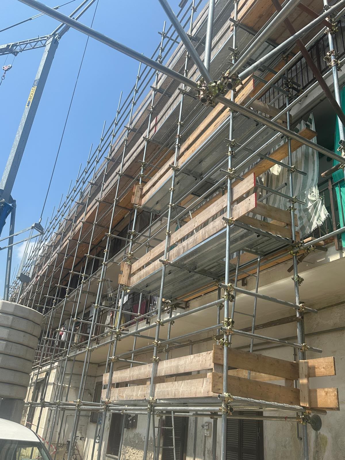 Impalcature attorno a un edificio in costruzione sullo sfondo di un cielo azzurro.
