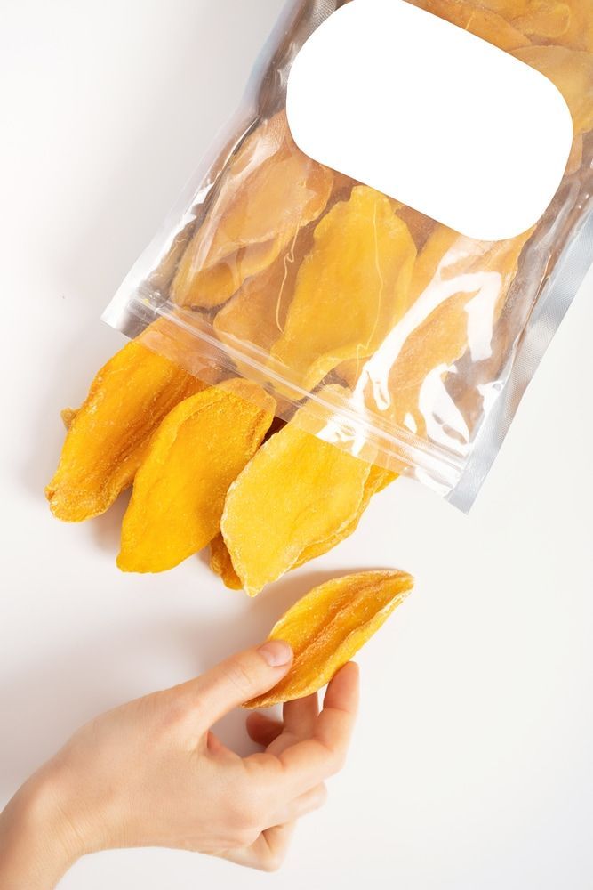 A Person Is Holding A Piece Of Dried Mango Bag — Central Fruit & Vegetable Wholesalers Pty Ltd In Alice Springs, NT