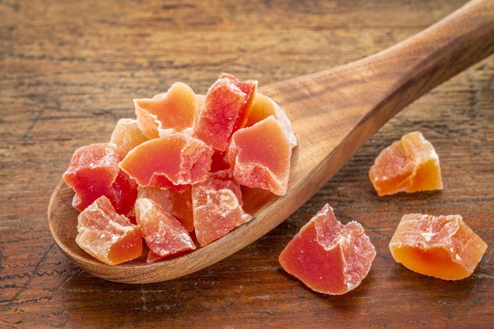 A Spoon Filled With Dried Papaya On A Wooden Table — Central Fruit & Vegetable Wholesalers Pty Ltd In Alice Springs, NT