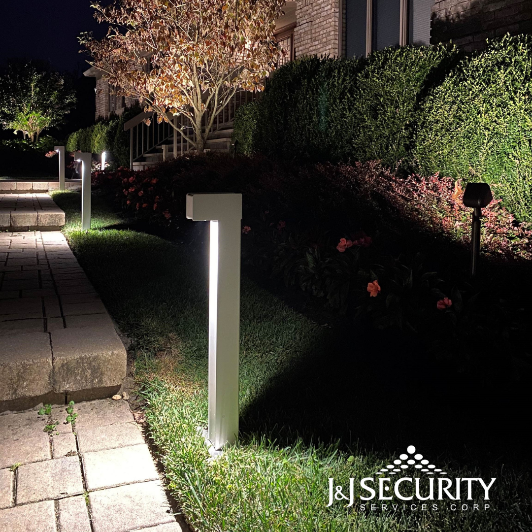 Pathway illuminated by modern silver bollard lights.