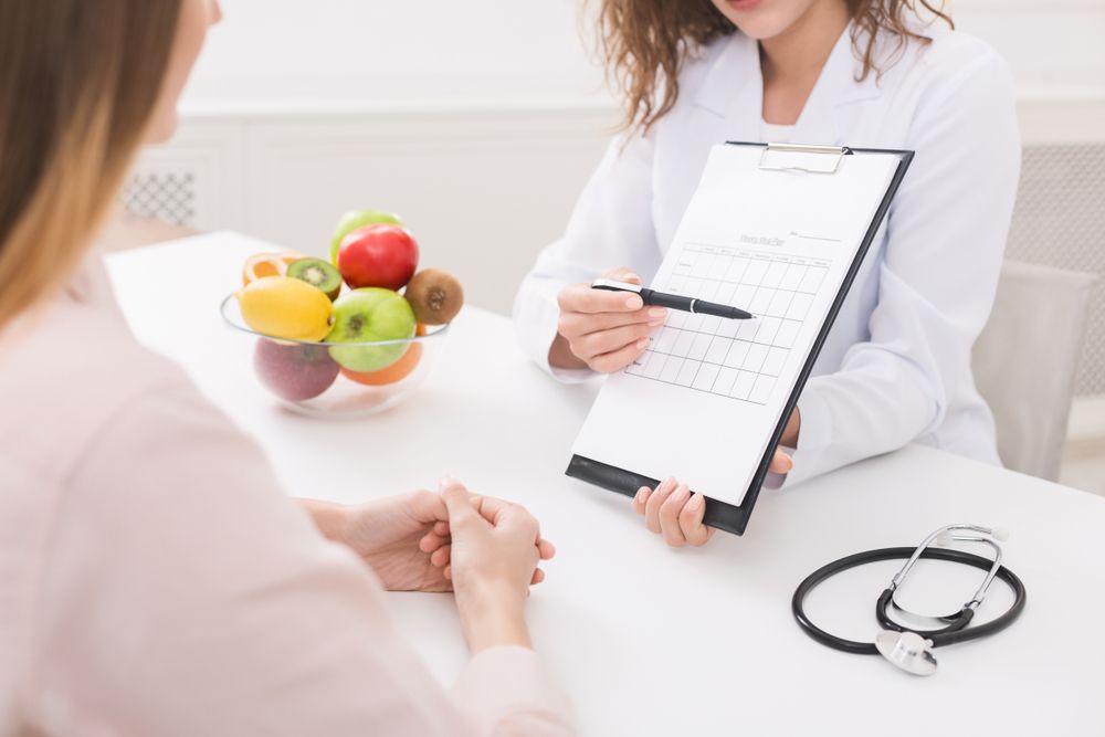 Dietician Pointing at a Chart, Speaking With a Patient — Mullumbimby Comprehensive Health Centre in Mullumbimby, NSW