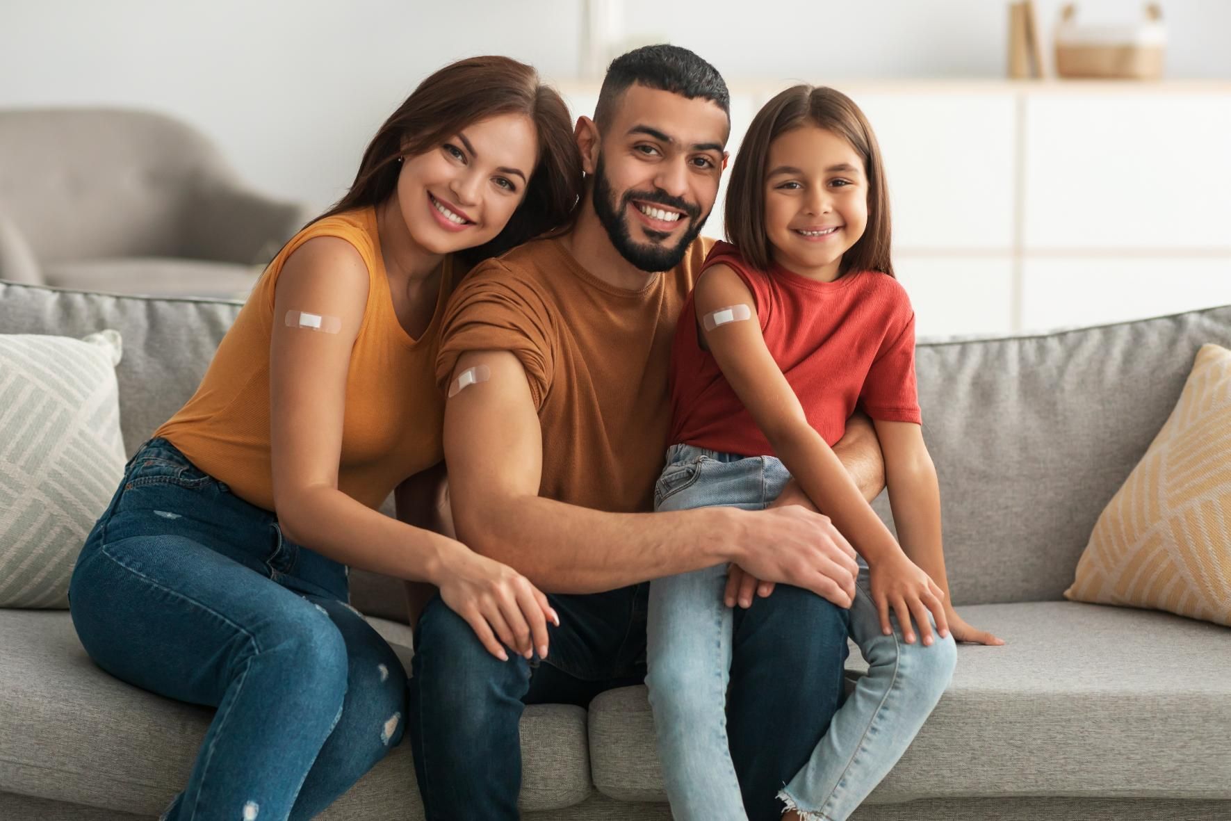 Family is Sitting on a Couch With Bandages on Their Arms — Mullumbimby Comprehensive Health Centre in Mullumbimby