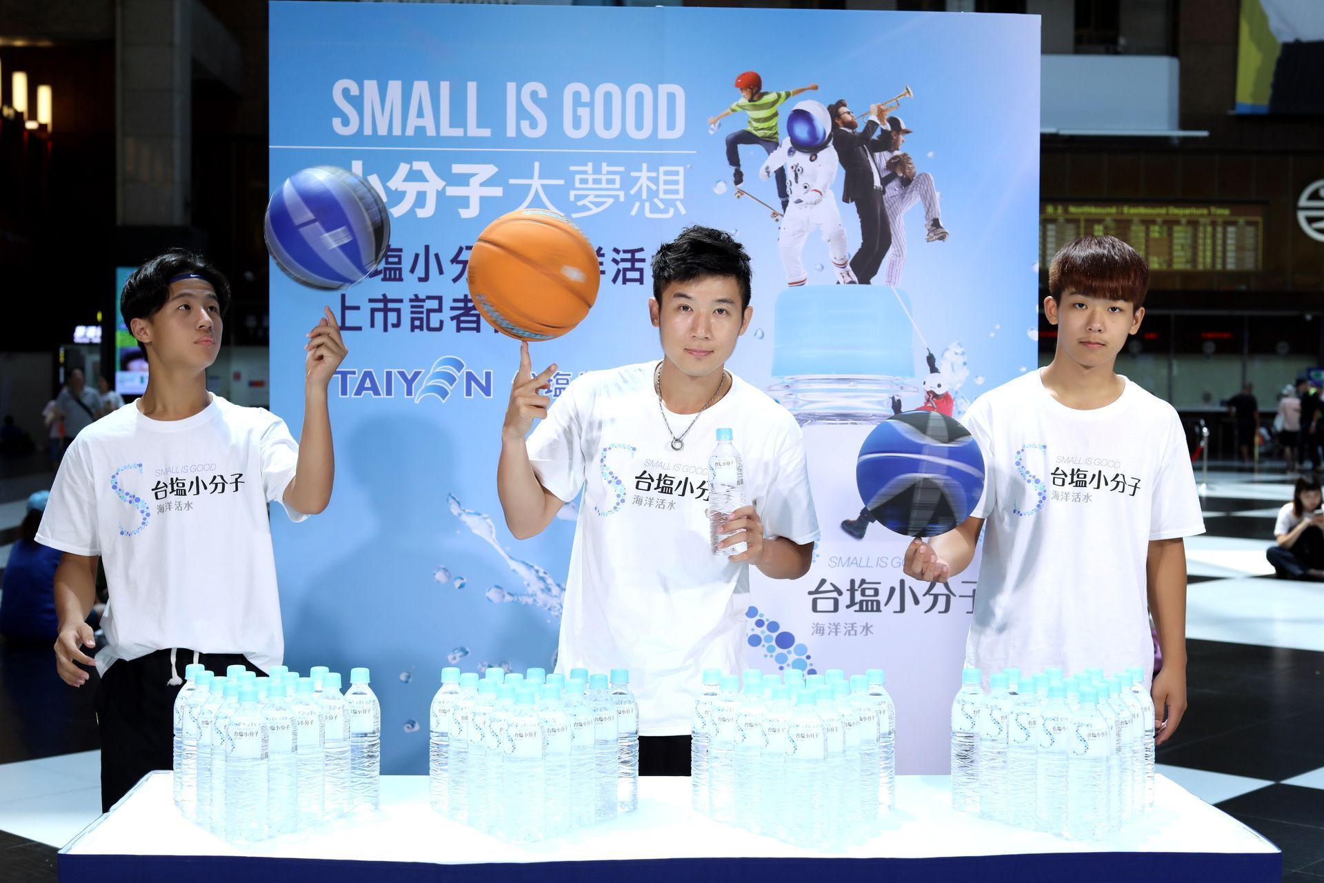 Three men with bottles and balls promoting 