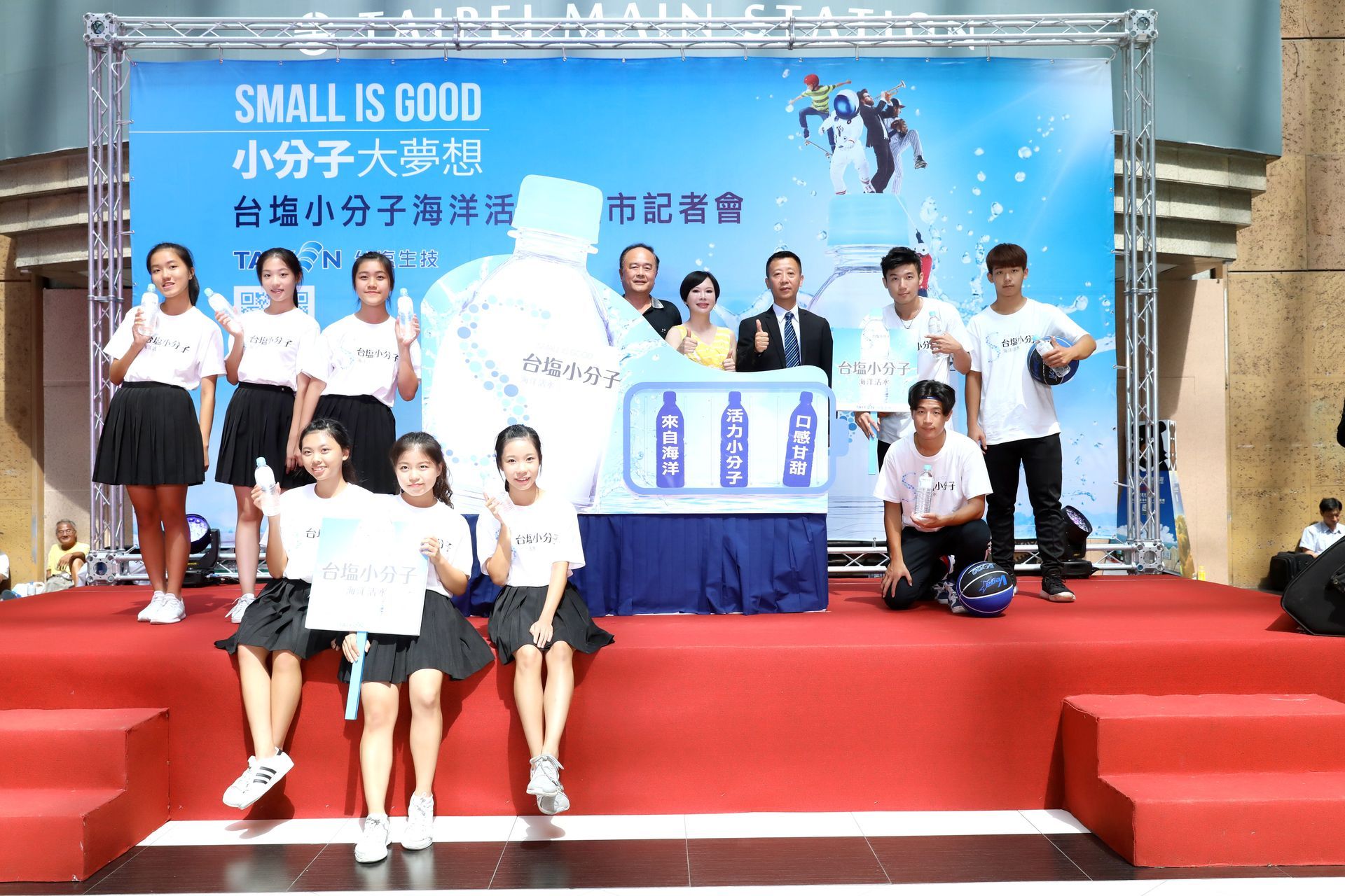 People on a stage with a banner reading 