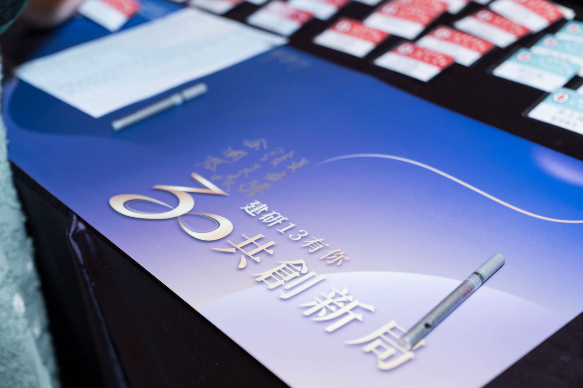 Blue table with text and a pen, cards in background.