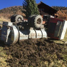 Un tracteur repose sur le côté dans la terre.