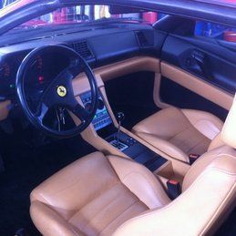 L'intérieur d'une voiture avec des sièges en cuir marron et un volant.