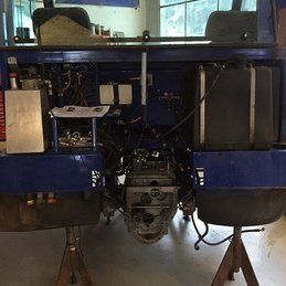 Un camion bleu est assis sur un support en bois dans un garage.
