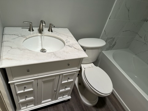 A man is fixing a sink in a kitchen.