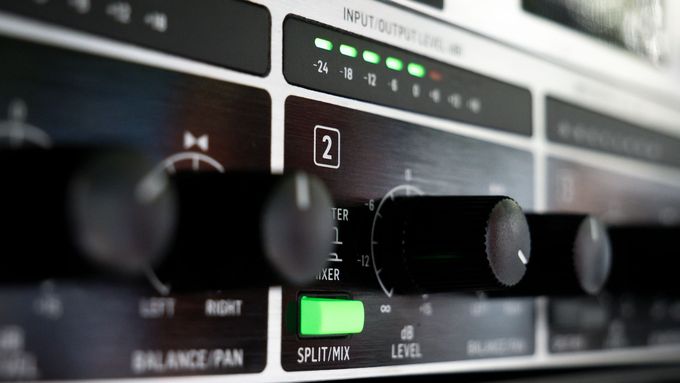 Nahaufnahme der Frontplatte eines schwarzen Audio-Receivers mit Drehknöpfen, LEDs sowie Reglern für Balance und Lautstärke.