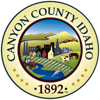 Canyon County, Idaho seal: Landscape with town, farming, and river, surrounded by text and stars.