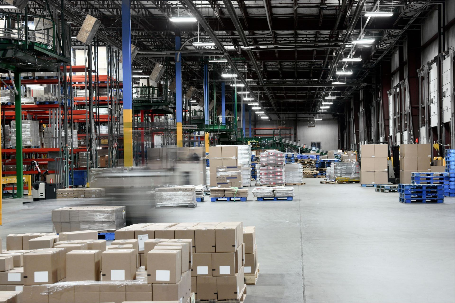 Warehouse interior with stacked boxes and pallets in a large industrial storage area