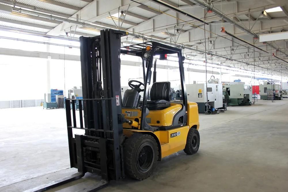 Yellow forklift parked in a warehouse aisle under bright ceiling lights