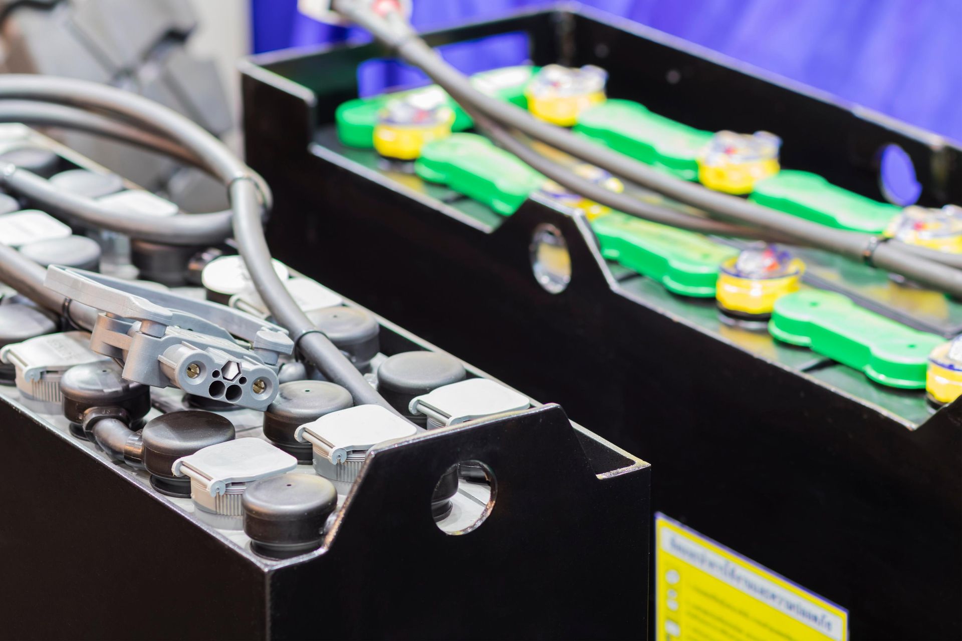 Close-up of industrial batteries with connected cables and green terminals