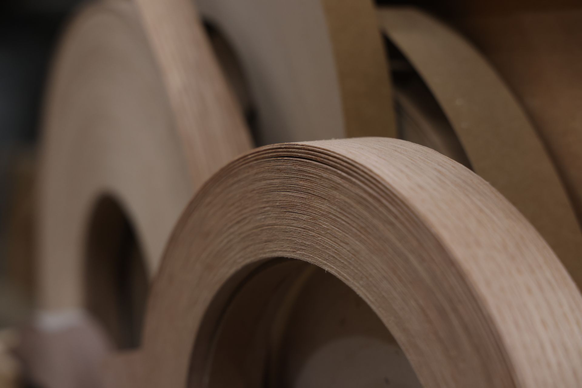 Close-up of stacked rolls of brown paper or cardboard in a workshop.