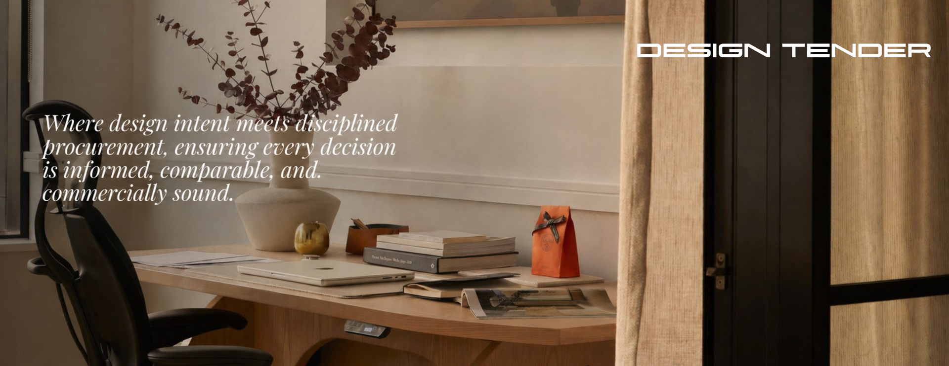 Warm beige workspace with desk, books, lamp, black chair, and vase of dried branches by a window