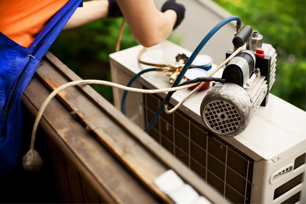 Hvac Technician Working on an Ac Unit Outdoors — Les Carman Cooling Solutions in Cardwell, QLD