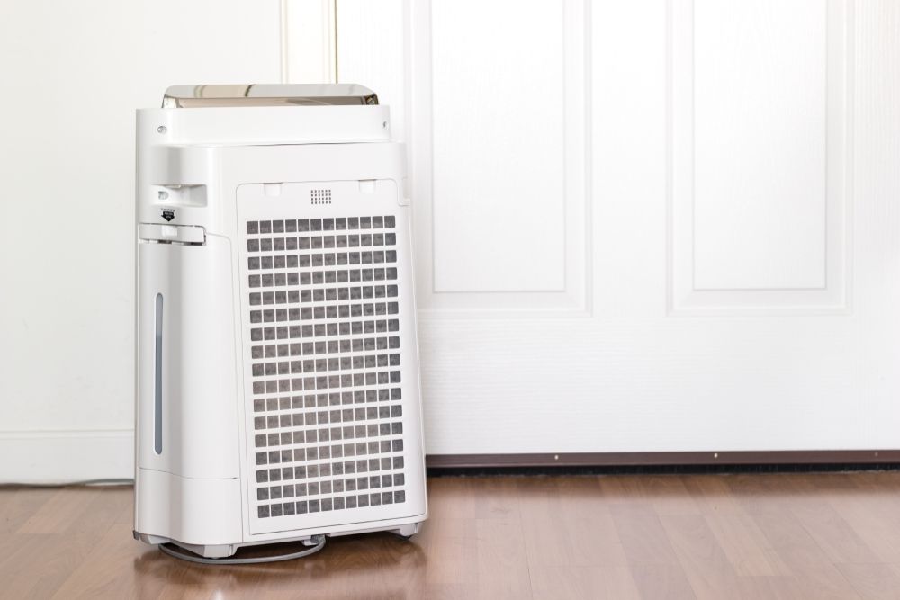 White Air Purifier on Wooden Floor — Les Carman Cooling Solutions in Tully, QLD
