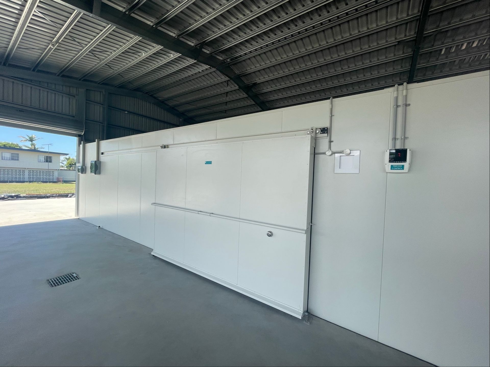 Empty Covered Walkway With White Wall Panels — Les Carman Cooling Solutions in El Arish, QLD