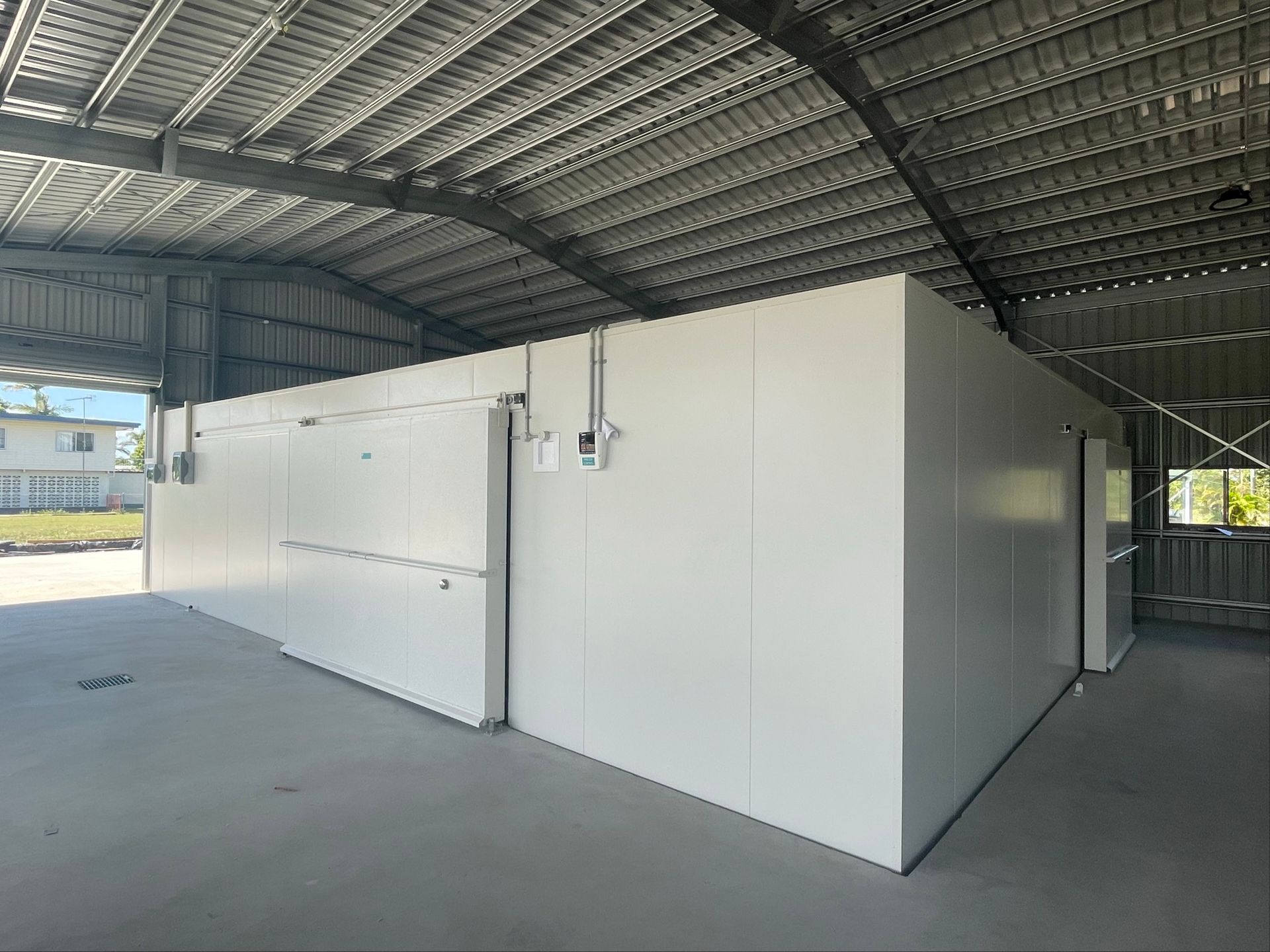 White Modular Building Under a Large Metal-roofed Structure — Les Carman Cooling Solutions in El Arish, QLD