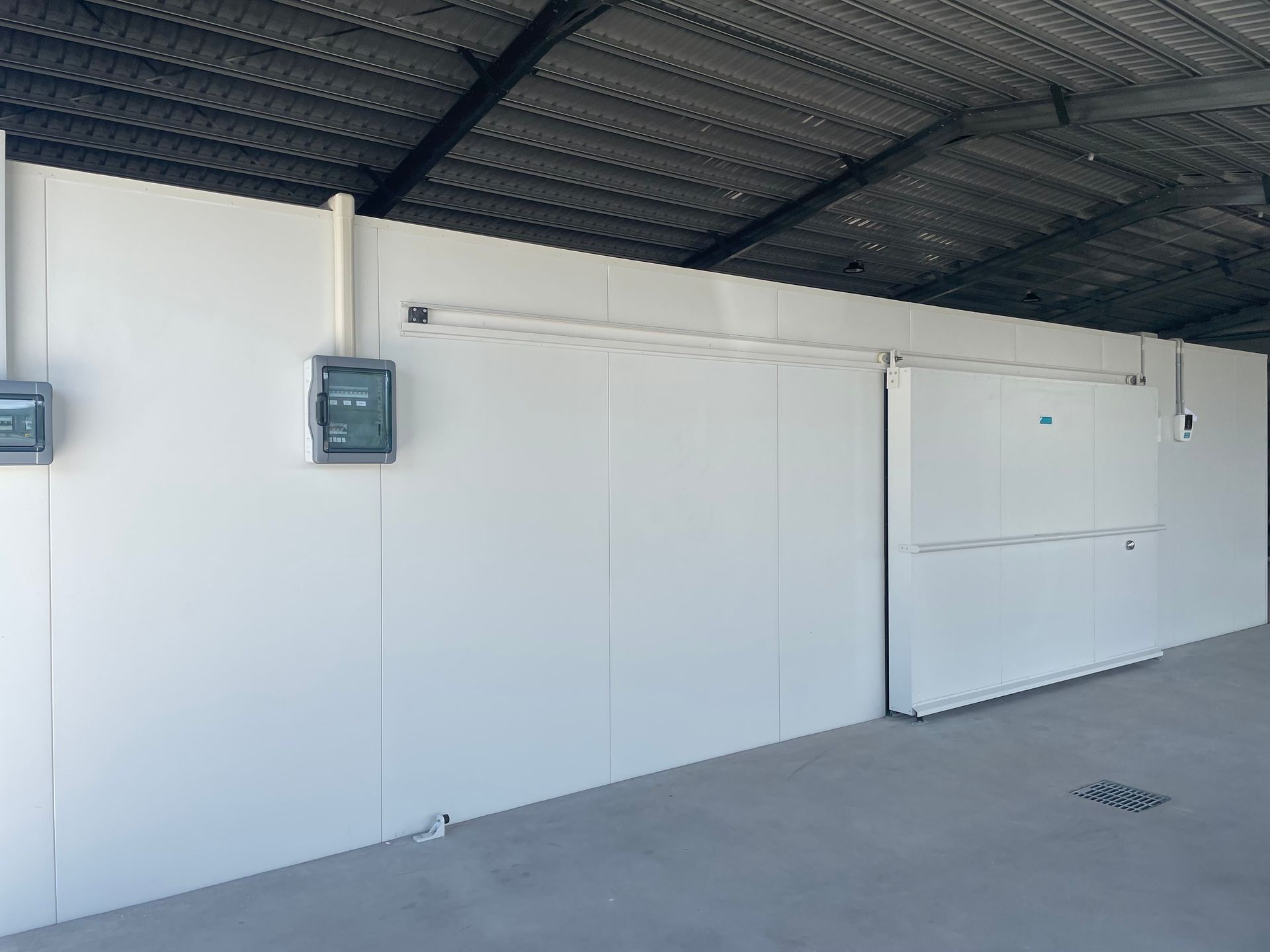 Covered Exterior Walkway With White Wall, Electrical Boxes — Les Carman Cooling Solutions in El Arish, QLD