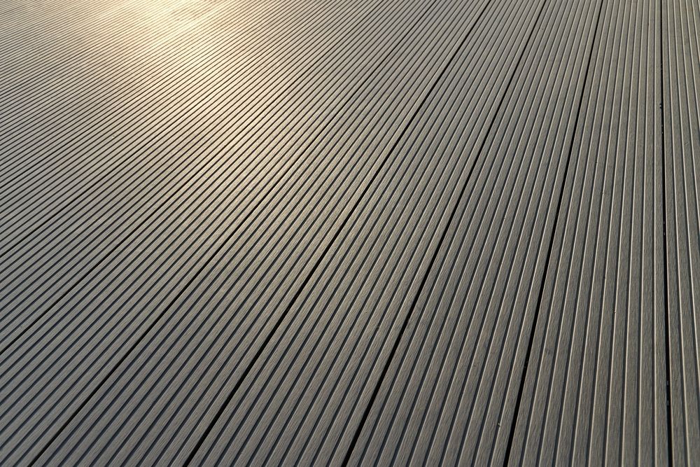 Close-up of gray, grooved, wooden planks on a curved surface with highlights.