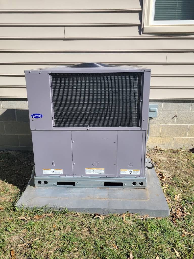 Outdoor HVAC unit on a concrete pad beside a house