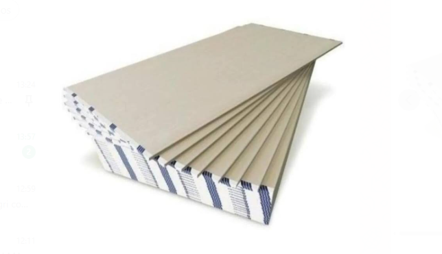 Pila de láminas de cartón corrugado beige extendidas en un paquete ordenado