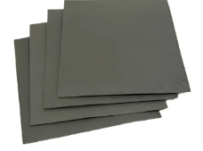 Pila de hojas cuadradas de papel de lija de color gris oscuro sobre un fondo blanco.