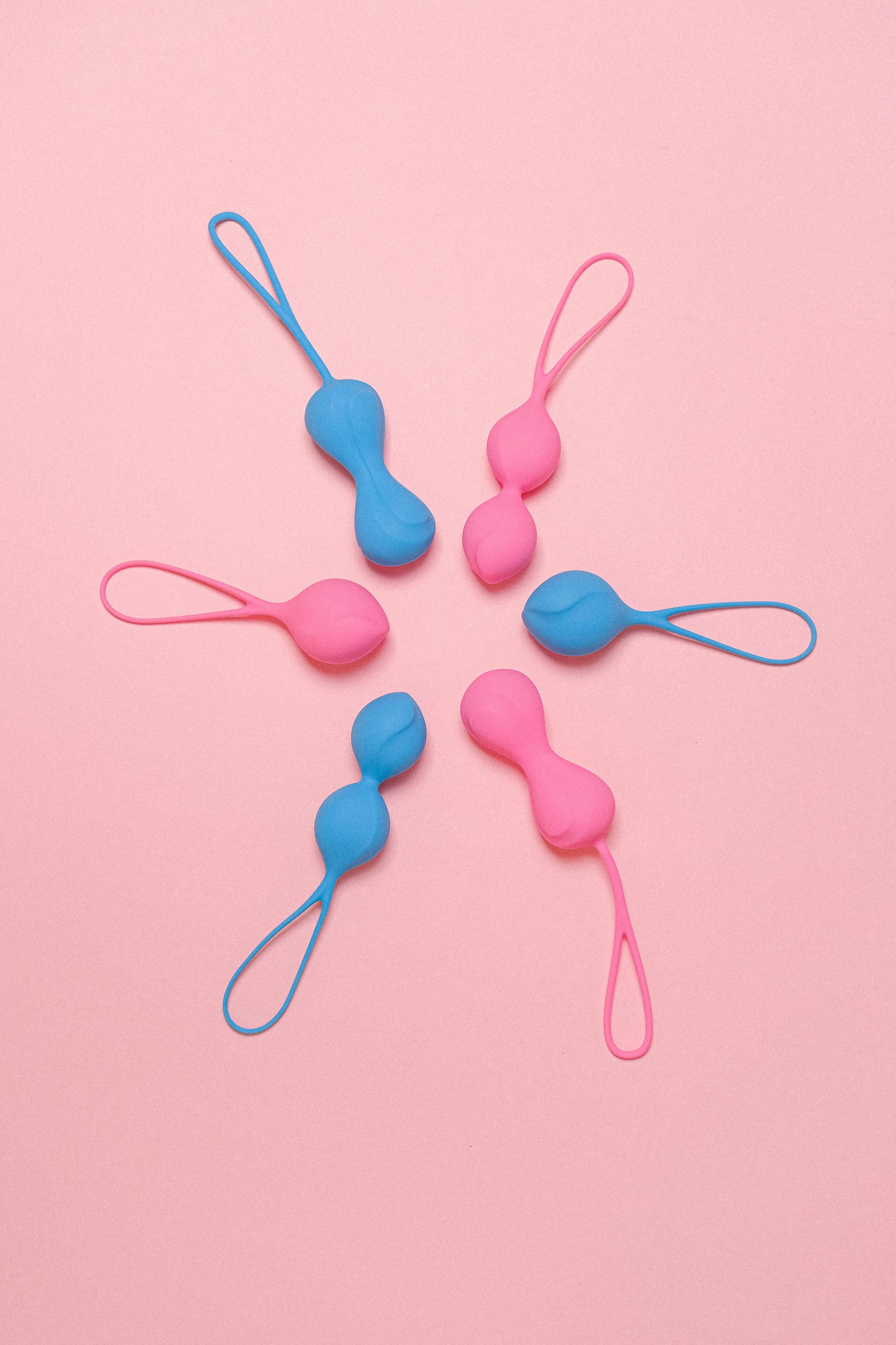 Las bolas rosas y azules están dispuestas en un círculo sobre un fondo rosa.