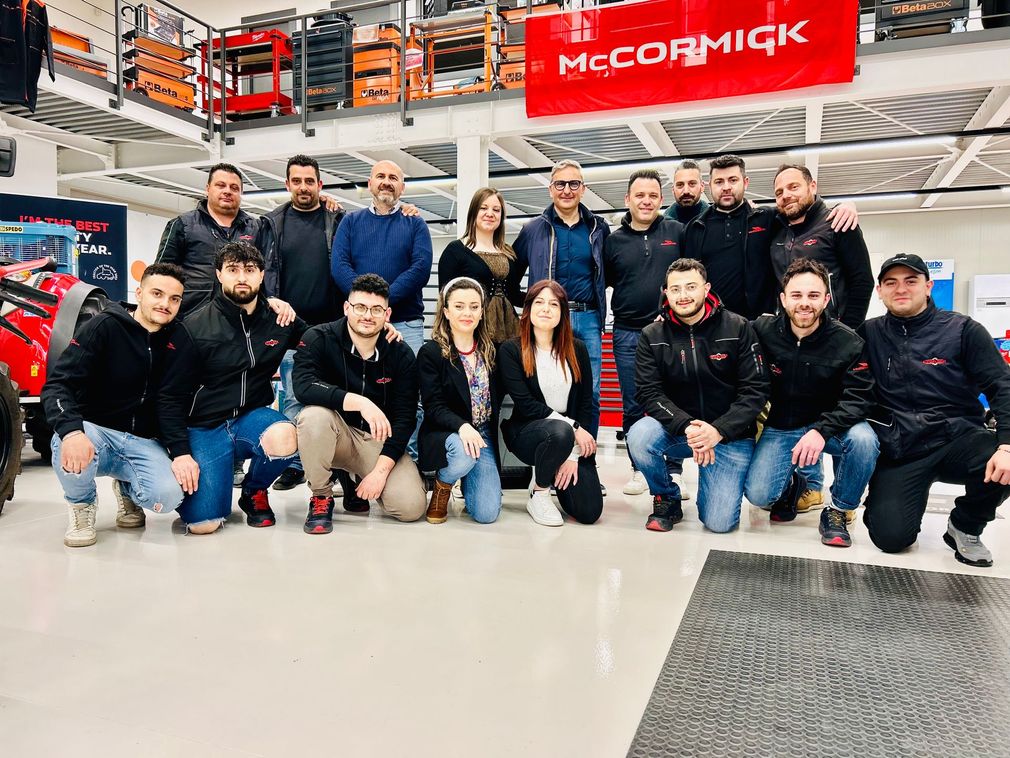 Gruppo di persone in posa insieme all'interno di un magazzino con un cartello della McCormick.
