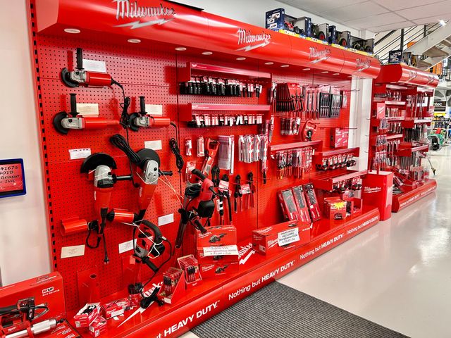 Elettroutensili e accessori Milwaukee rossi esposti sullo scaffale di un negozio.