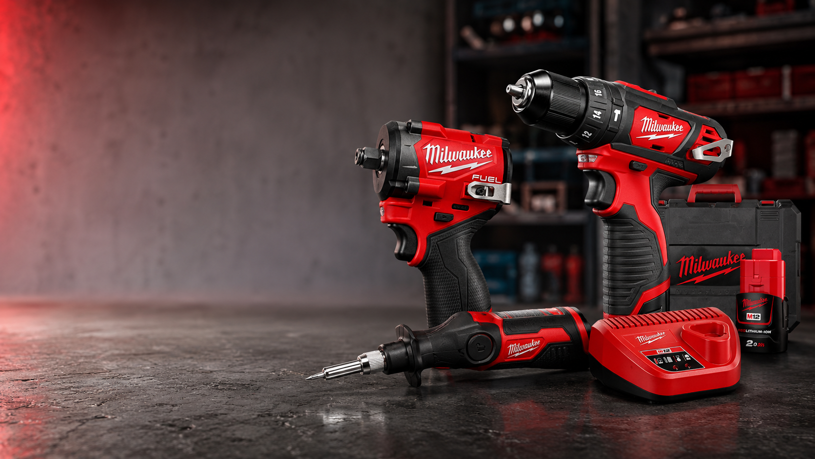 Set di trapano a batteria rosso e nero su un pavimento di cemento con sfondo grigio.