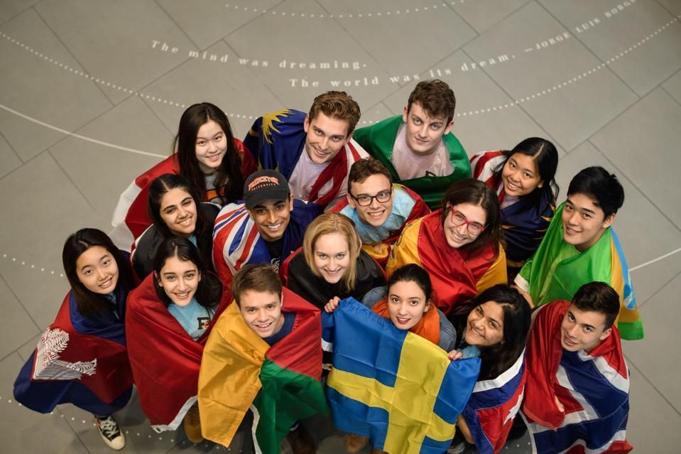 Un groupe de personnes souriantes se rassemble, brandissant un drapeau suédois bleu et jaune.