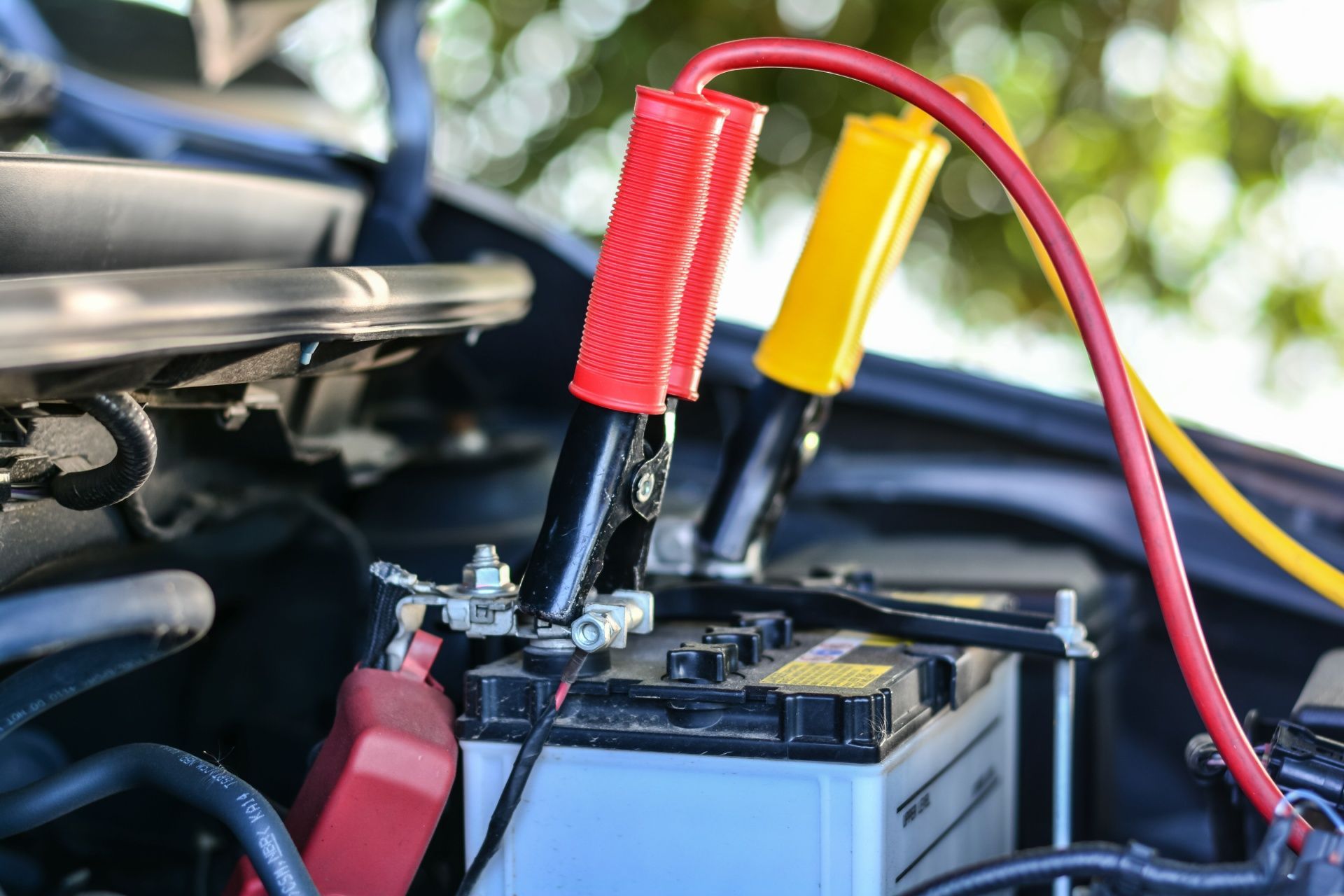 A man is using a jump starter to start a car.