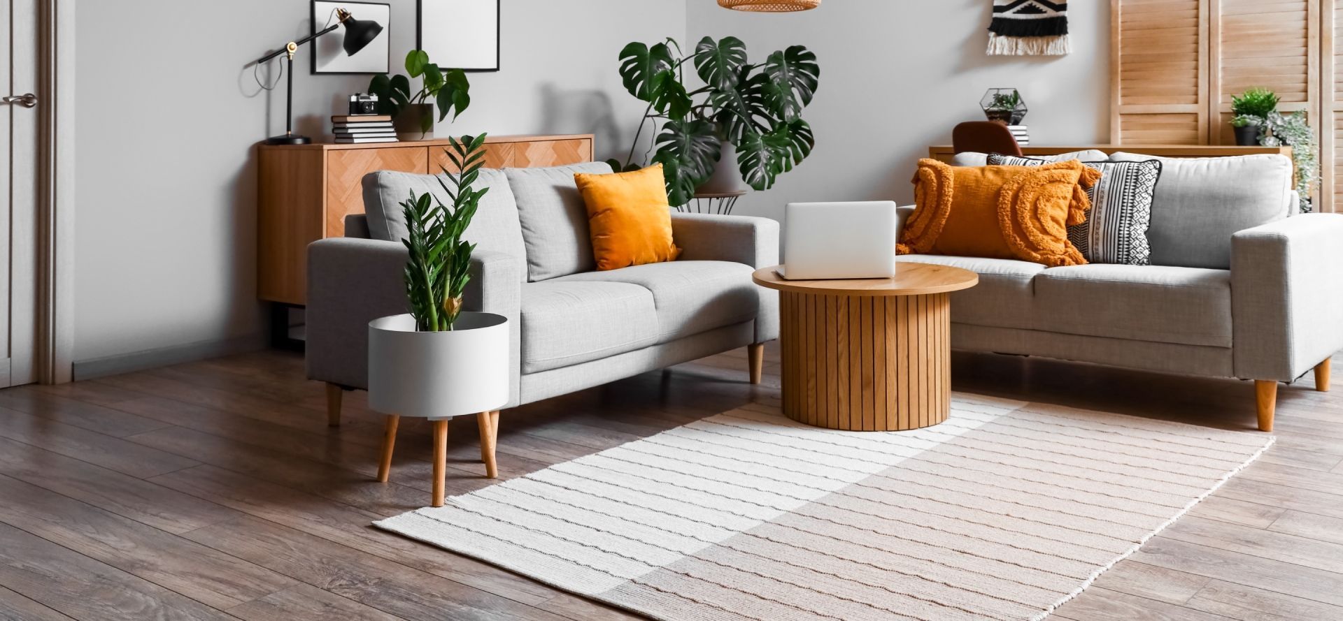 A living room filled with furniture and a laptop on a table.