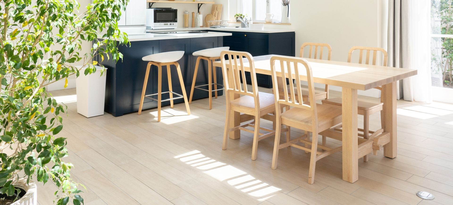 A dining room with a wooden table and chairs in a kitchen.