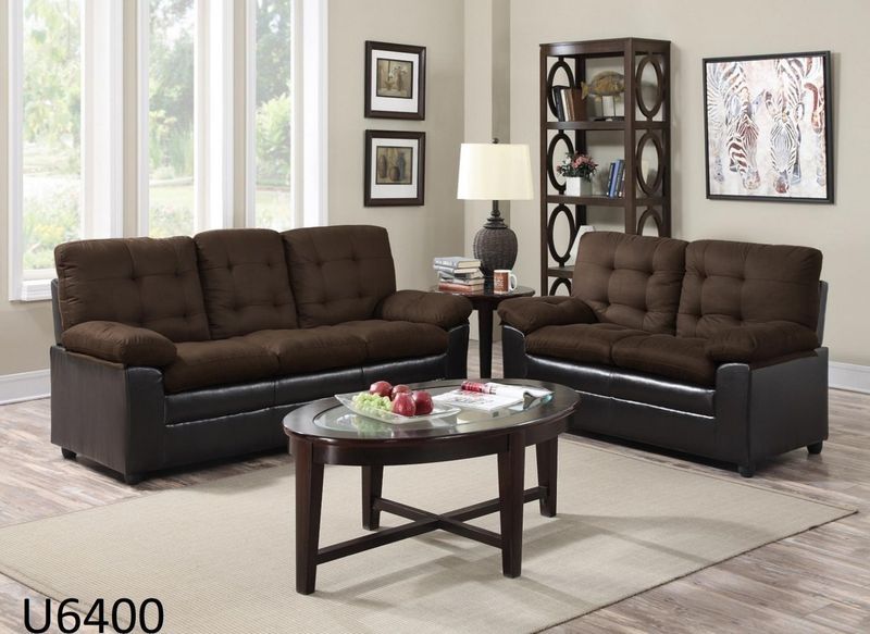 A living room with two brown couches and a coffee table