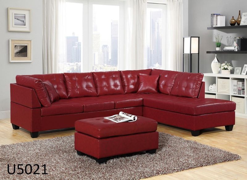 A living room with a red sectional couch and ottoman